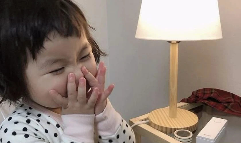 Em bé đang cười "thật tươi" với đôi mắt nhắm tịt