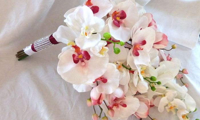 Cô dâu rạng rỡ với bó hoa lan hồ điệp trắng tinh khôi cầm tay trong ngày cưới