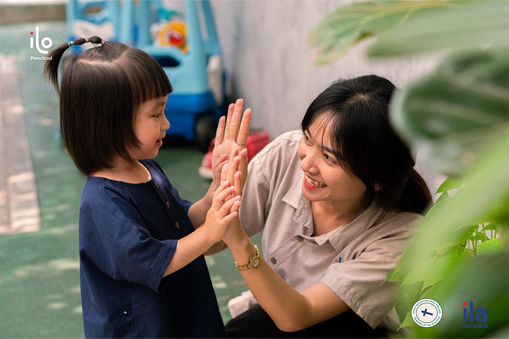 Cô giáo ân cần ôm một học sinh nhỏ tuổi thể hiện sự yêu thương